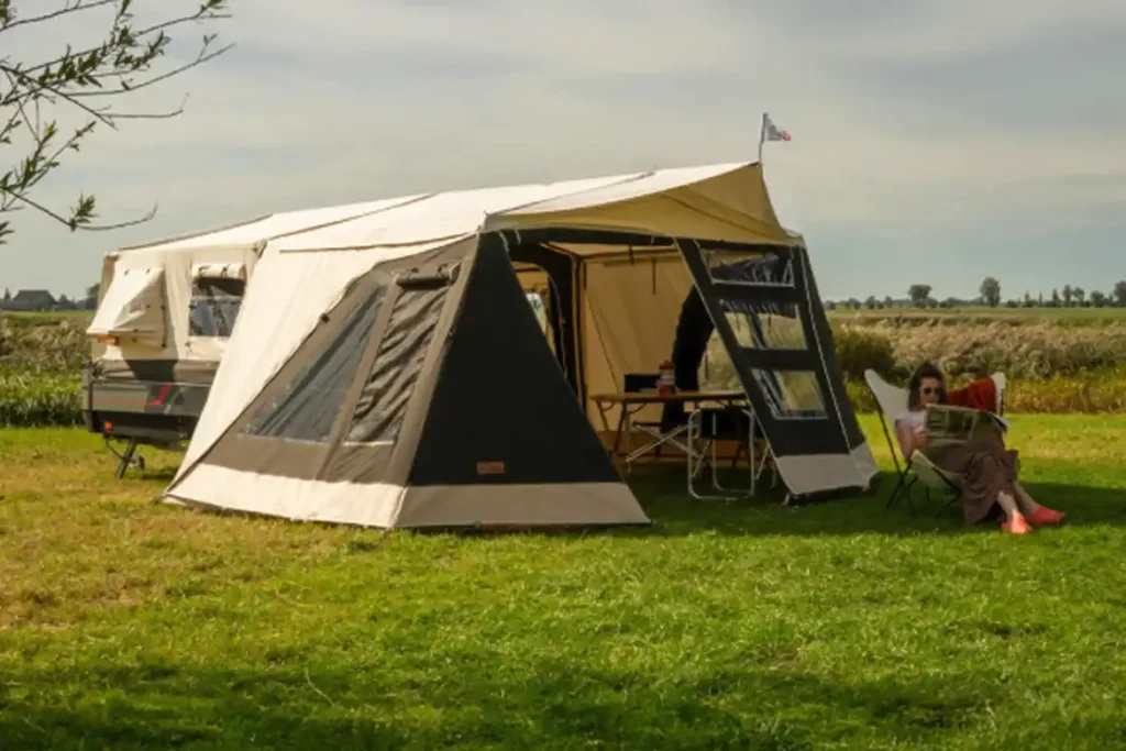 The trailer tent fully opened at a campsite.
